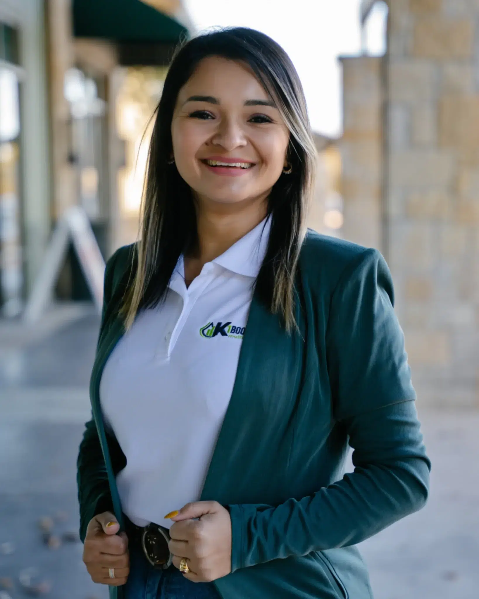 Karenmia Meléndez, K1 Bookkeeping's CEO, smiling outdoors in a company-branded blazer